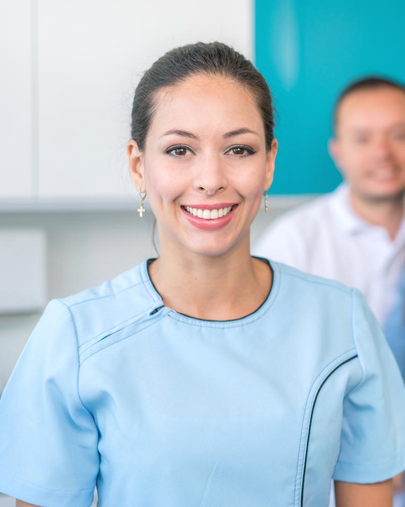 A female dental professional smiles at the camera